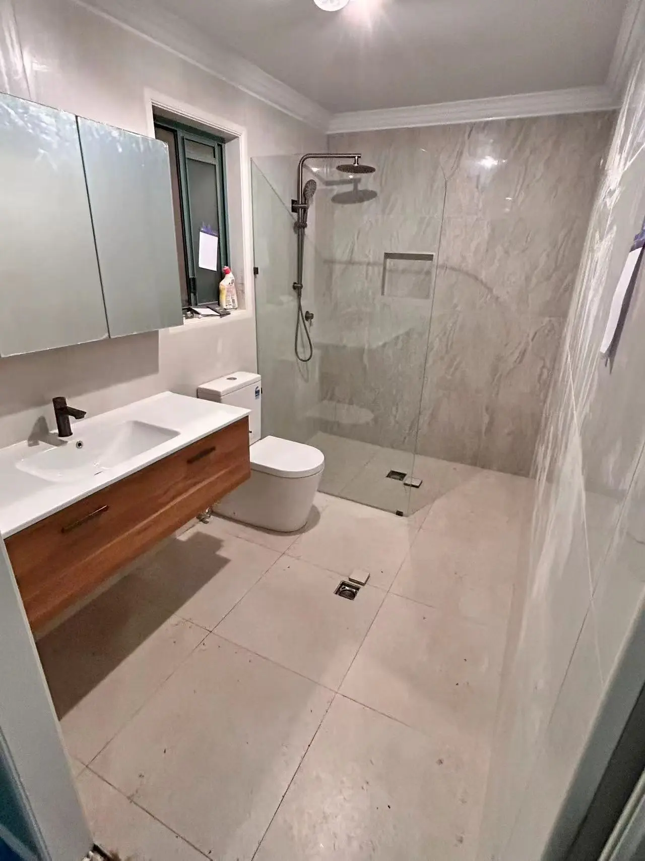 Completed tiled bathroom with timber vanity, toilet and walk-in shower