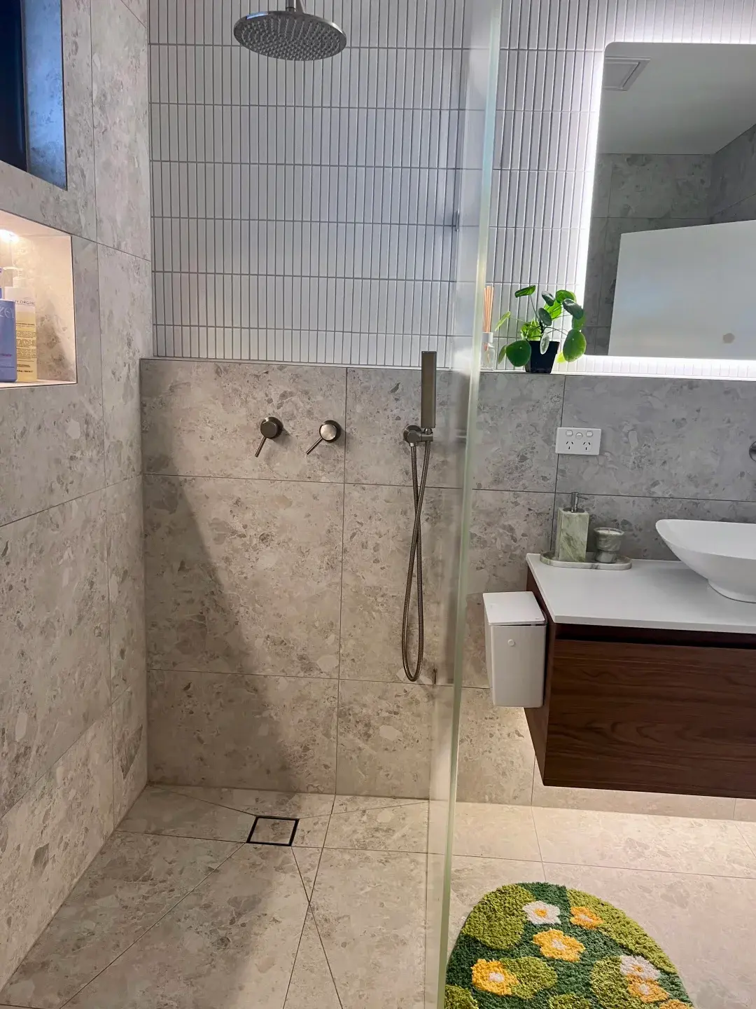 Finished walk-in shower with stone-look tiles, rainfall shower and recessed shelf