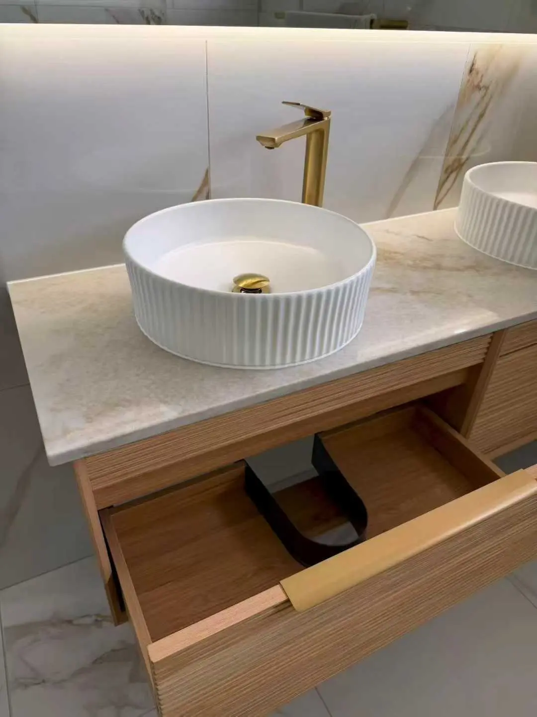 Timber bathroom vanity with stone benchtop, vessel basins and brushed-gold tapware